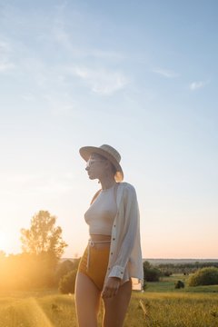 Sunset portrait of young daydreaming woman