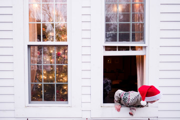 Boy with Santa hat in window on Christmas