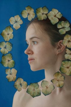 Side view portrait of young woman with floral frame