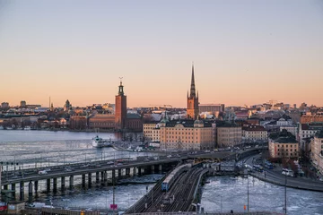 Zelfklevend Fotobehang Stockholm treinrails die bij zonsondergang naar het centrum van stockholm zweden leiden