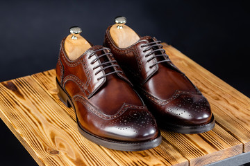 stylish leather brown shoes against a dark background.