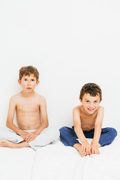 Two brothers sitting in bed.
