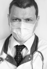 Portrait of a young caucasian doctor wearing protective mask with serious expression banner panoramic blue background. COVID-19 Coronavirus concept