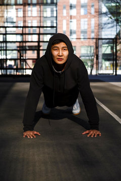 Asian guy exercising on sports ground