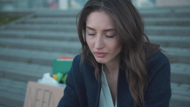 Young depressed woman sits down on stairs feel tired of searching occupation. Need Job protest banner. Office belongings. Pandemic crisis 2020. Quarantine.