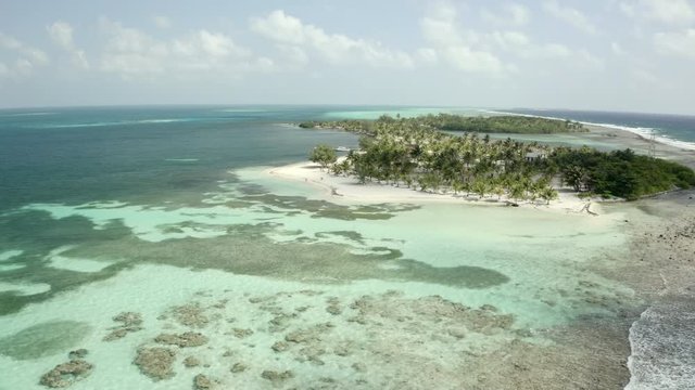 Aerial: Drone approaching waves in sea against sky, island at beach during sunny day - Coco Plum Cay, Belize