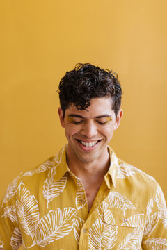 portrait of young happy man against yellow background in matching shirt