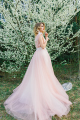Young beautiful woman in blooming garden. Bride.