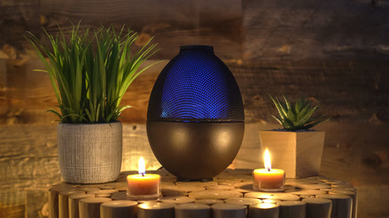 Electric oil diffuser lamp, candles on wooden table in room.