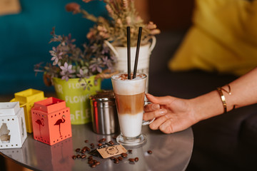 Close up of woman's hand and coffee on the table at caffee shop