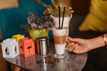 Close up of woman's hand and coffee on the table at caffee shop