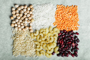  Red lentils, white rice, beans, pasta and chickpeas on a grey background. Healthy food concept. Ingredients for cooking.
