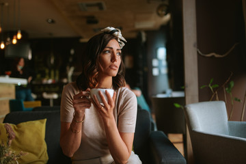 Attractive young caucasian woman drinking espresso in a cafe