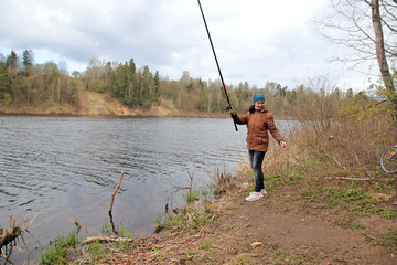 woman with fishing rod on the river