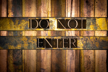 Photo of real authentic typeset letters forming Do Not Enter text on vintage textured grunge copper background