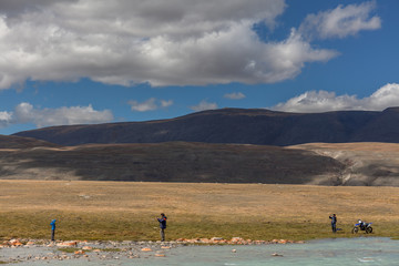 A family enjoy beautiful views of the mountains of the Mongolian Altai.