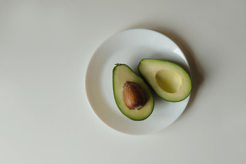 
slice avocado on plate on a white background close up