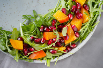 Bright persimmon arugula pomegranate seeds salad