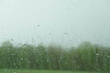 Regen auf der Windschutzscheibe und eine Landschaft