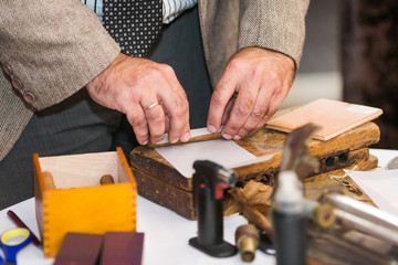 the hands of a tobacco expert test an experimental blend of tobacco sheets