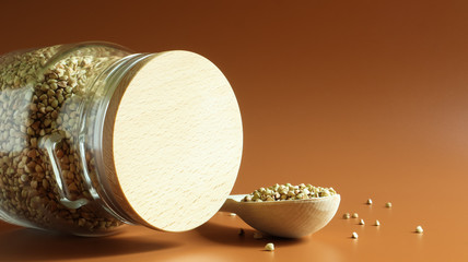 Green sprouts of raw organic buckwheat in a glass cereal jar with a wooden spoon. Vegan food...