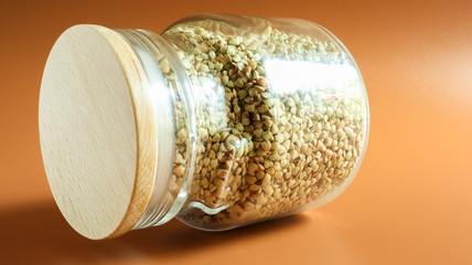 Green sprouts of raw organic buckwheat in a glass jar for cereals. Vegan food concept. Organic...