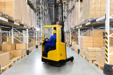Huge distribution warehouse with high shelves and forklift with driver. © hacohob
