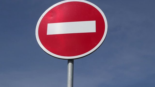 outdoor transportation sign no entry or do not pass against the blue sky background. restriction for cars and vehicles to drive
