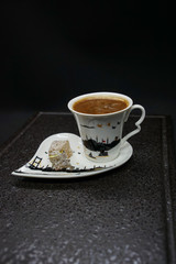 traditional Turkish coffee with Turkish delight. heart shaped saucers and traditional Turkish coffee on black granite   tray in black background. Coffee cups and saucers with the symbols of istanbul.