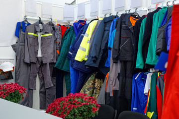 Wide view of  wear clothes, dresses, skirts, trousers, jackets, shoes with shelves, racks and hangers inside fashion retail store in  large mall.