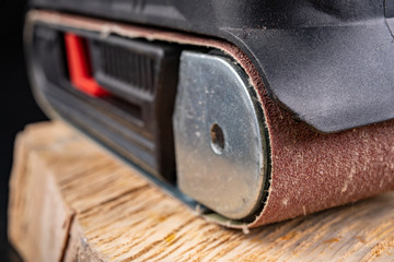 A belt sander for wood. Accessories for small carpentry work.