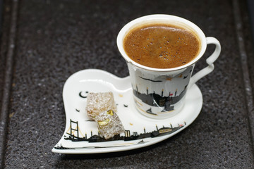 traditional Turkish coffee with Turkish delight. heart shaped saucers and traditional Turkish coffee on black granite   tray in black background. Coffee cups and saucers with the symbols of istanbul.