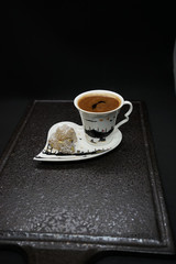 traditional Turkish coffee with Turkish delight. heart shaped saucers and traditional Turkish coffee on black granite   tray in black background. Coffee cups and saucers with the symbols of istanbul.