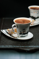 traditional Turkish coffee with Turkish delight. heart shaped saucers and traditional Turkish coffee on black granite   tray in black background. Coffee cups and saucers with the symbols of istanbul.