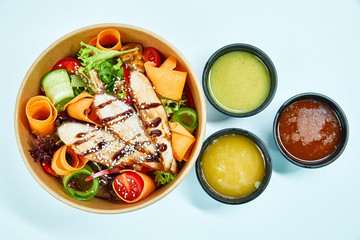 Salad with grilled duck and cherry tomatoes, red pepper, pumpkin, cucumber, lettuce, grilled mushrooms, in a cardboard box