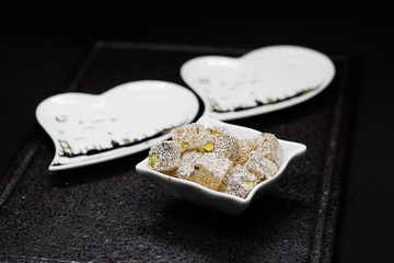 traditional Turkish coffee with Turkish delight. heart shaped saucers and traditional Turkish coffee on black granite   tray in black background. Coffee cups and saucers with the symbols of istanbul.
