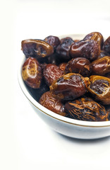 Juicy fasli dates in a bowl on white background