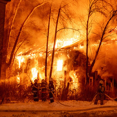 Fire, burning old house at night, firefighters extinguish