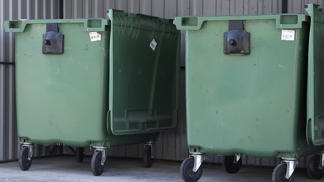 three plastic green trash cans for separated garbage