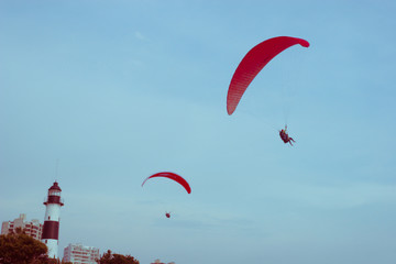 personas volando en parapente sobre el mar