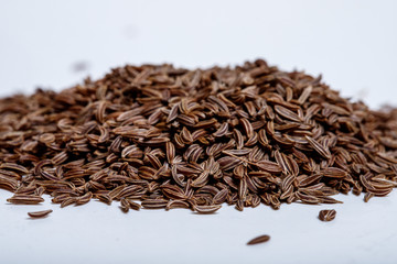 Pile of cumin seeds isolated on white background