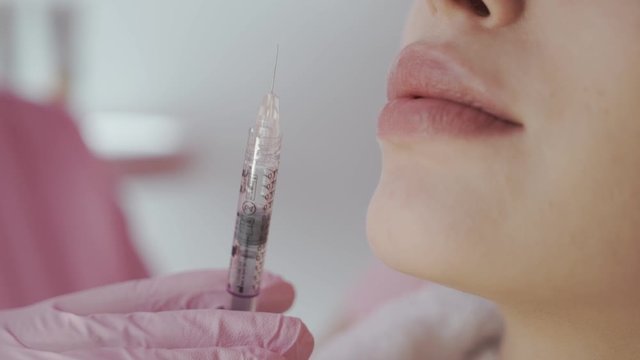 Close up Young woman having botox injection into her lips