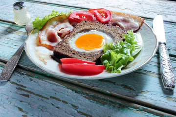 Fried eggs, omelet traditional rustic breakfast, fried eggs, roasted bacon, sausage for breakfast .  Healthy food