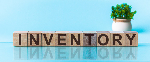 Word INVENTORY made with wood building blocks on a blu back ground