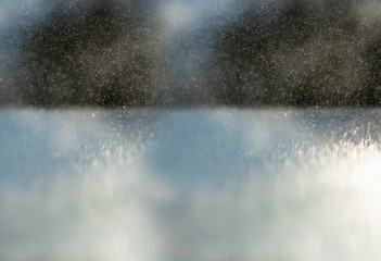 Small drops of water beaten by the sun in the counter-jour form gray abstractions