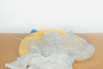 The concept of recycling plastic and ecology. Garbage made of plastic and polyethylene lies on brown paper. side view on a white background