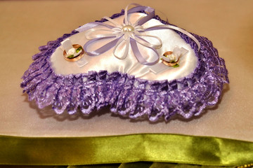 Festive pillow with gold wedding rings