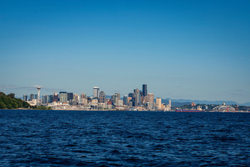 Fototapeta na wymiar The downtown Seattle skyline rises above Elliot Bay on a beautiful sunny afternoon as seen from the waters of Puget Sound.