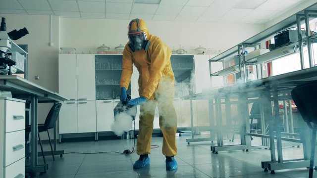 One man uses a sprayer to sanitize a room during pandemic.