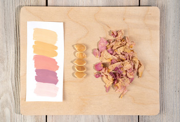 A color palette with samples of flowers taken from a dried field plant, and a place to write. On a wooden background. Composition for your design, postcards, invitations.